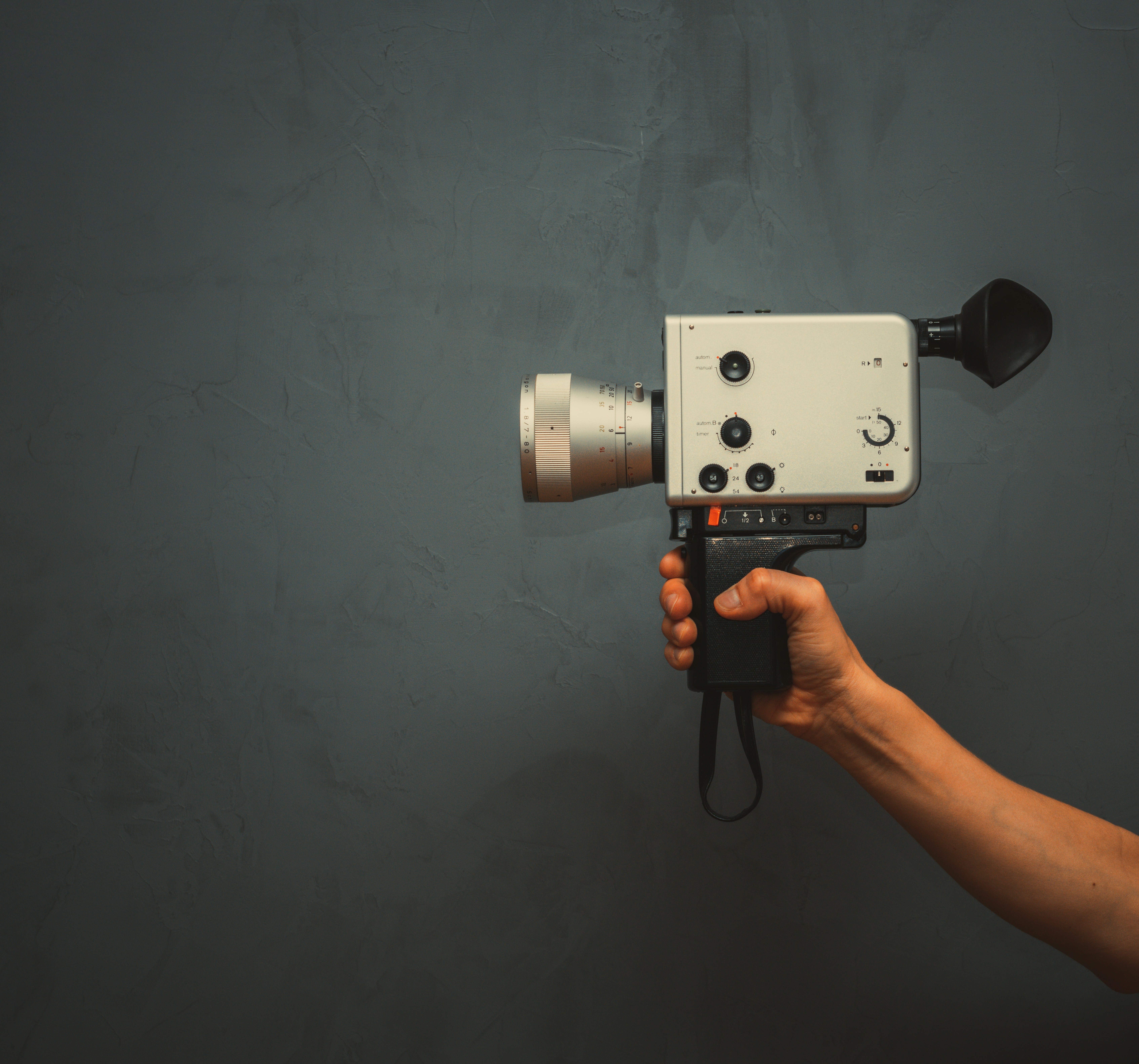 A Super 8 film camera resting beside film reels on a table, representing the textured, physical look of real film.